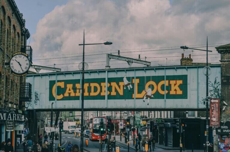Vibrant view of Camden Lock bridge with bustling street scene in London, England.