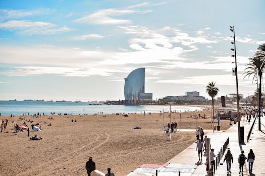 A vibrant day at Barceloneta Beach, showcasing the iconic W Hotel and lively atmosphere.